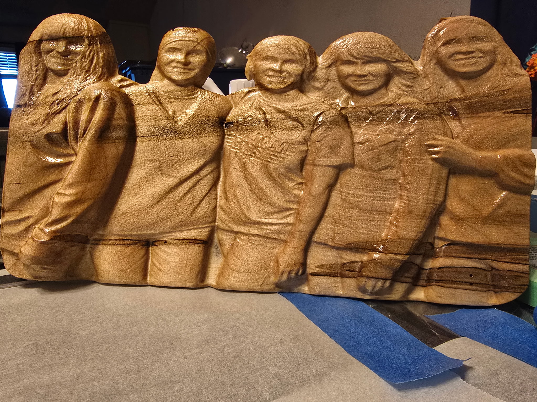 Carved 3D relief of a group of five people in wood