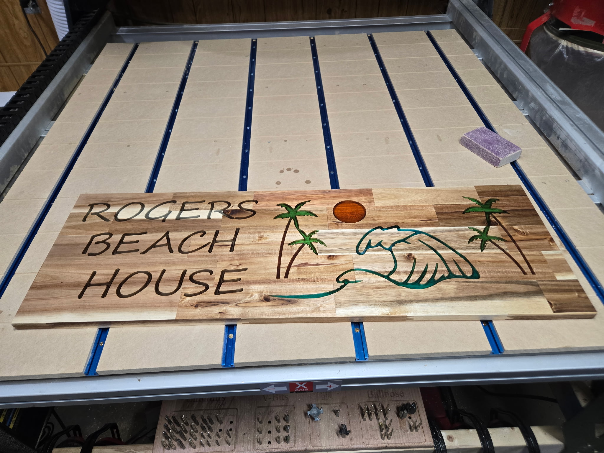 Carved Beach House sign with palm trees on the CNC router bed